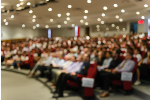 An audience at a conference session in an auditorium
