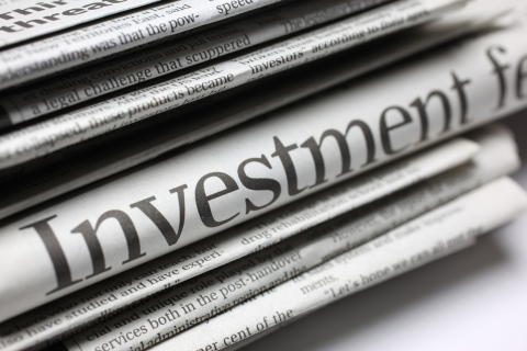 Stack of newspapers with the word investment prominent and in the center