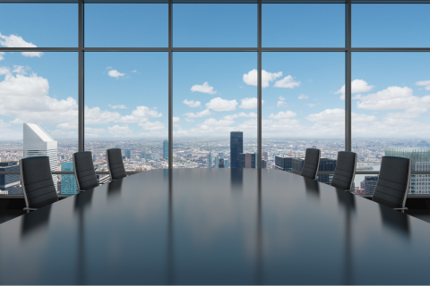 Conference table surrounded by chairs with blue sky in the background