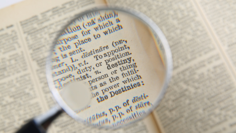 Magnifying glass over a dictionary entry for the word destiny